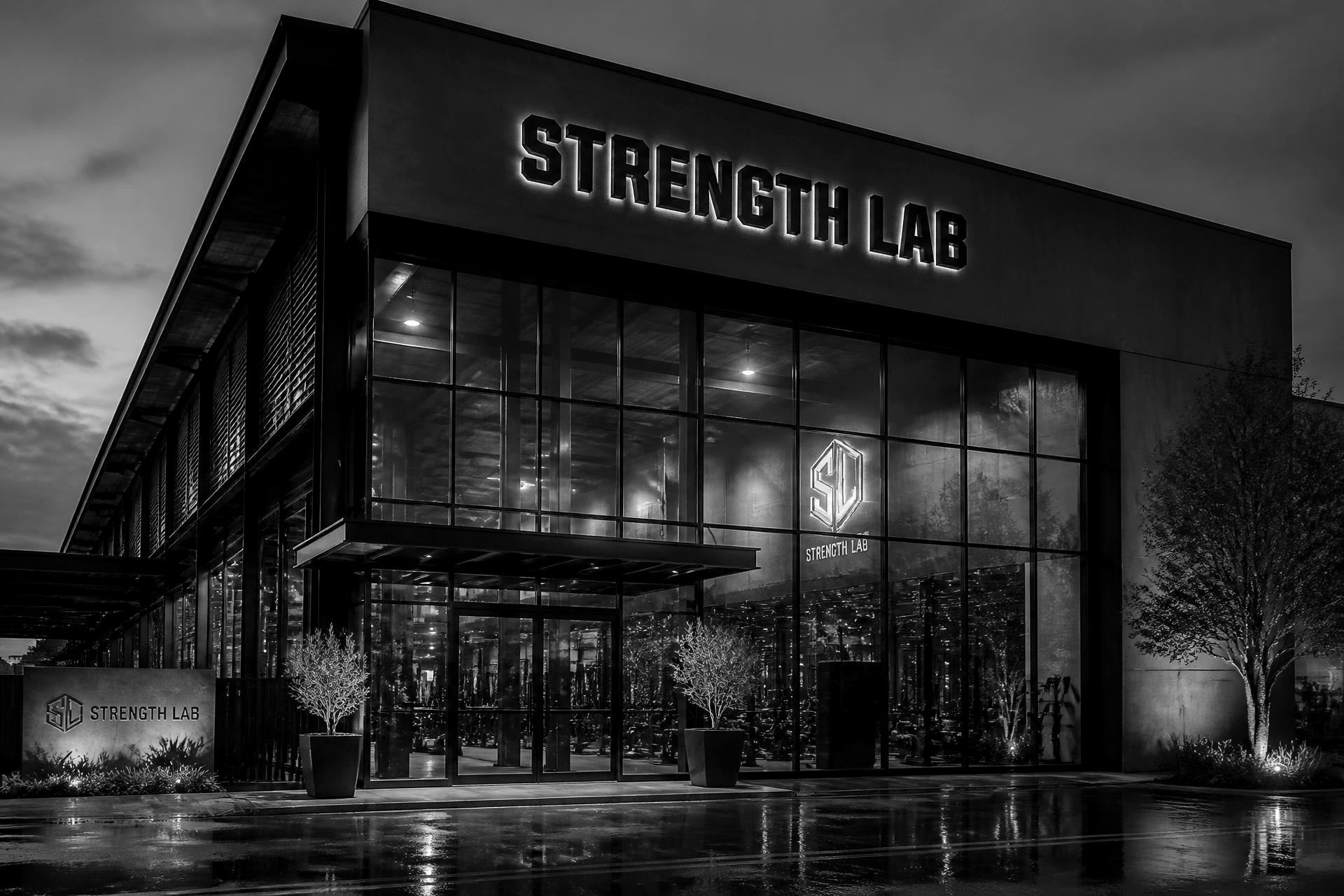 The lit entrance of the Strength Lab facility at dusk